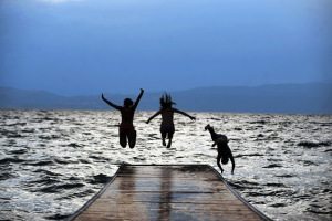 Three girls jump in  the Ohrid Lake in O