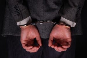 Arrested businessman handcuffed hands at the back